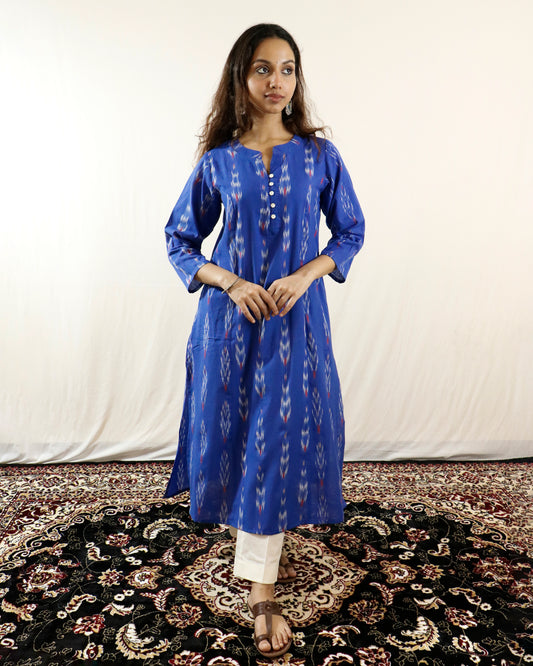 Woman wearing a blue kurta with white patterns on a white background